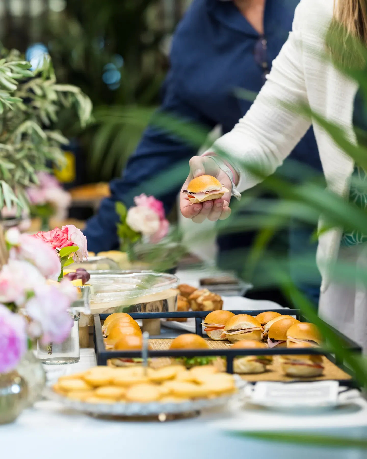 Canapés and salmon bites in glass cups, arranged on a white platter at a reception